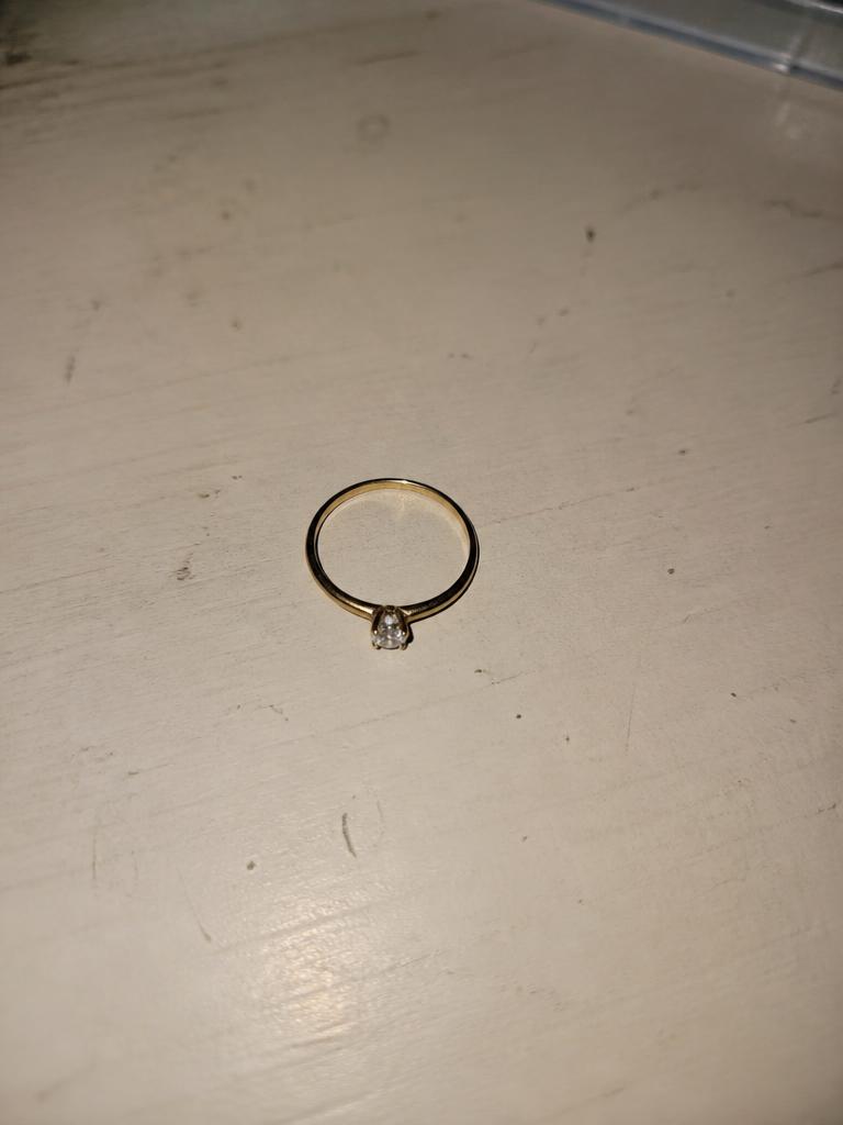 Foto do anel tirada no celular, sem tratamento, sobre uma mesa
